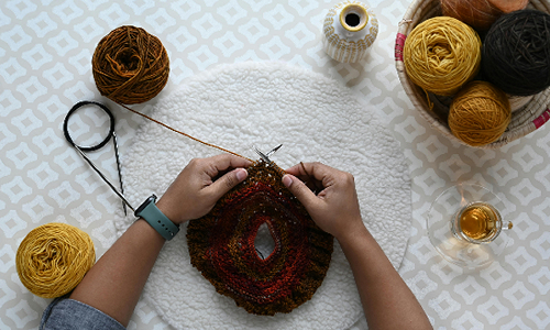 person knitting in the round